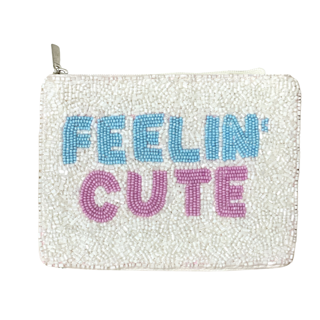 Pouch with 'FEELIN' CUTE' text in blue and pink on a white background