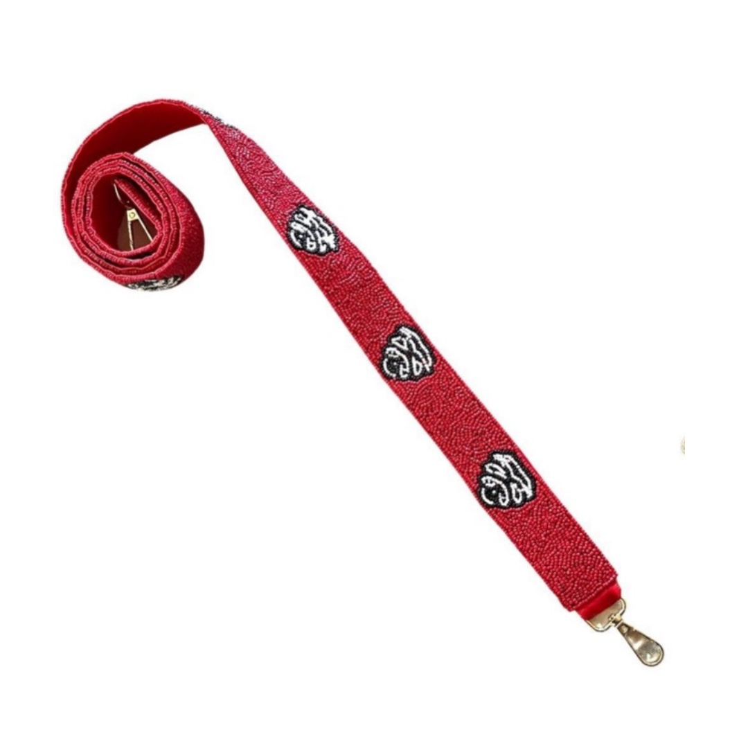 Red strap with decorative metal clasps on a white background