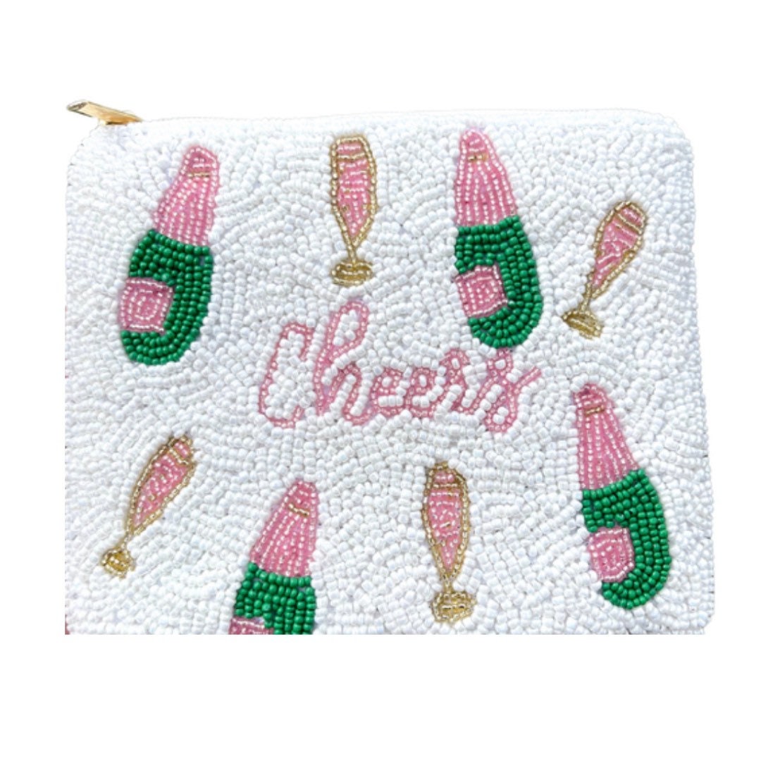 A beaded coin purse with the word 'CHEERS' embroidered on it, featuring a pattern of champagne bottles.