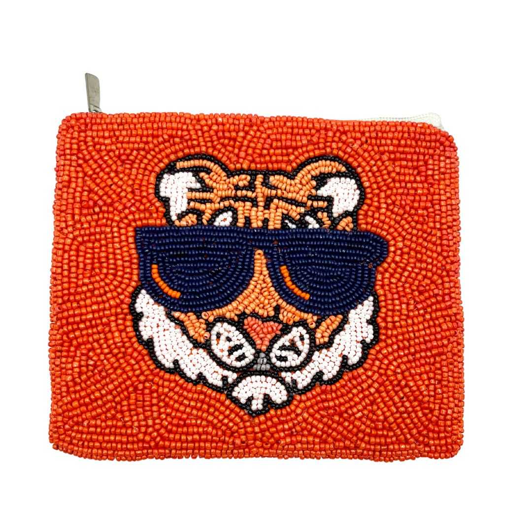Beaded pouch with tiger design and sunglasses on an orange background