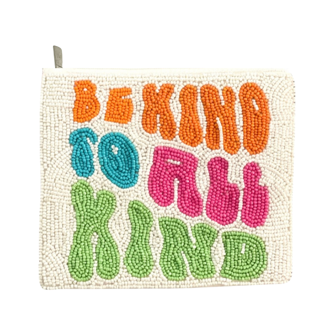 Decorative pillow with colorful text 'Be Kind to All Kind' on a white background