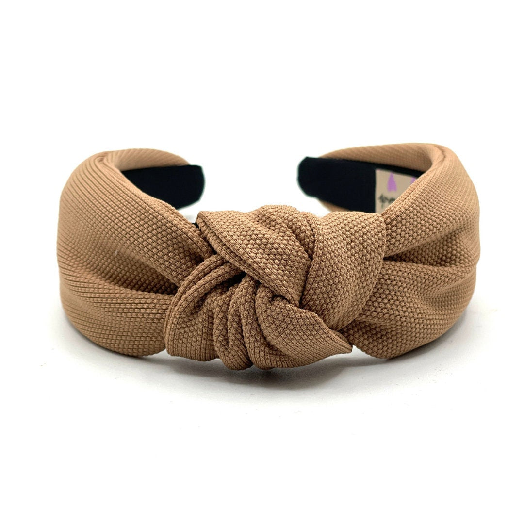 Brown knotted headband on a white background
