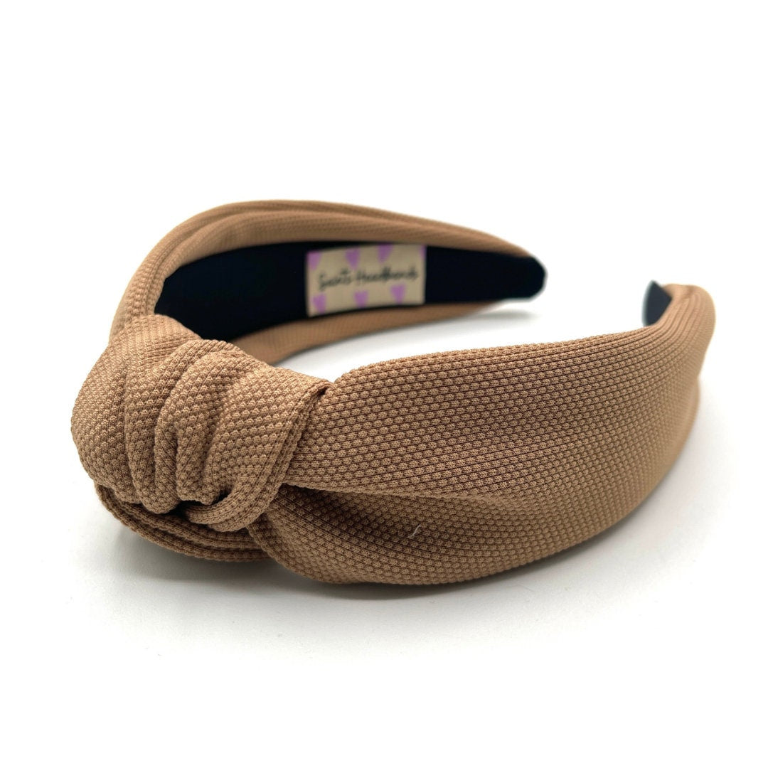 Brown knotted headband on a white background