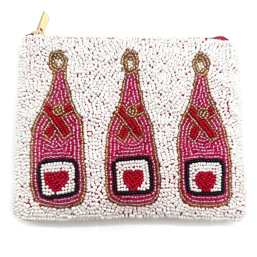 A small, beaded coin purse with a canvas backing, featuring hand-sewn seed beads in red, white, and gold colors, and adorned with the shape of champagne bottles with hearts.