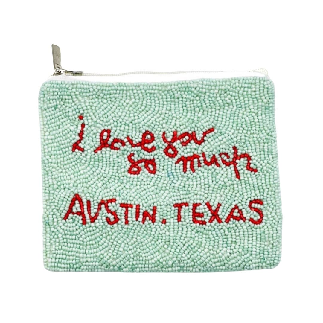 A small green beaded coin pouch with the text 'I love you so much Austin, Texas' written in red.
