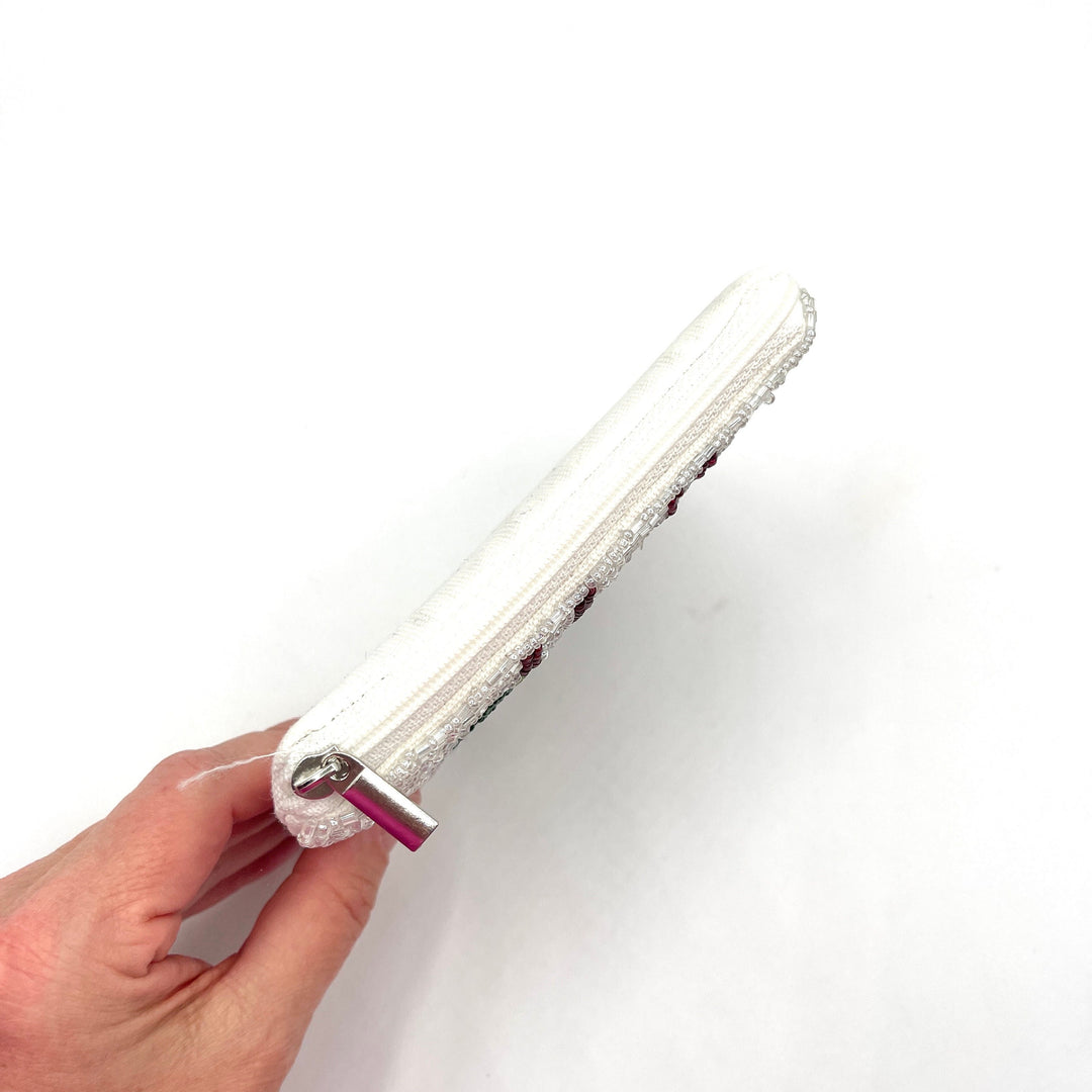 Hand holding a white phone case with glittery accents on a white background