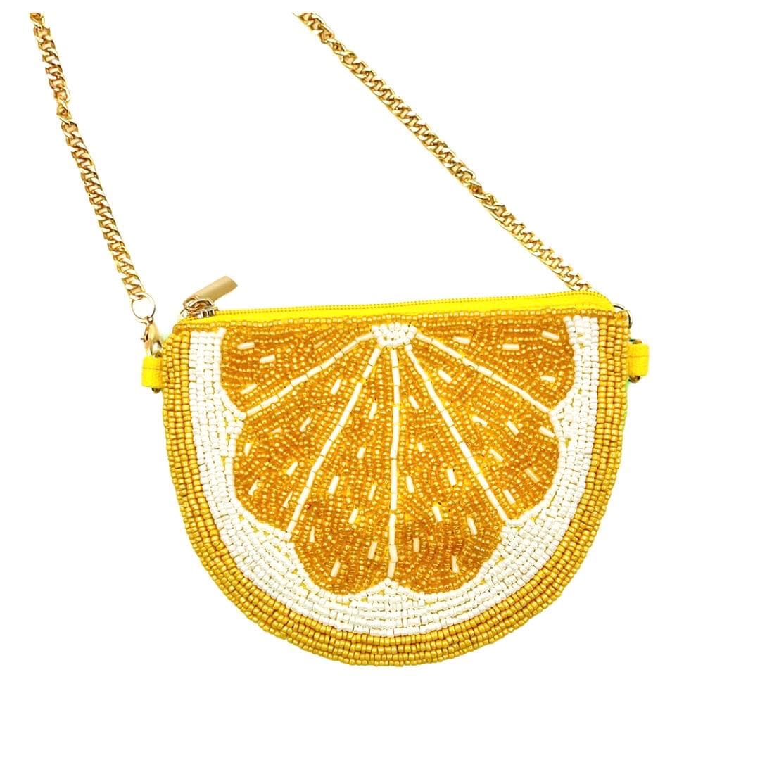 Handbag designed like a lemon slice with beaded details on a white background