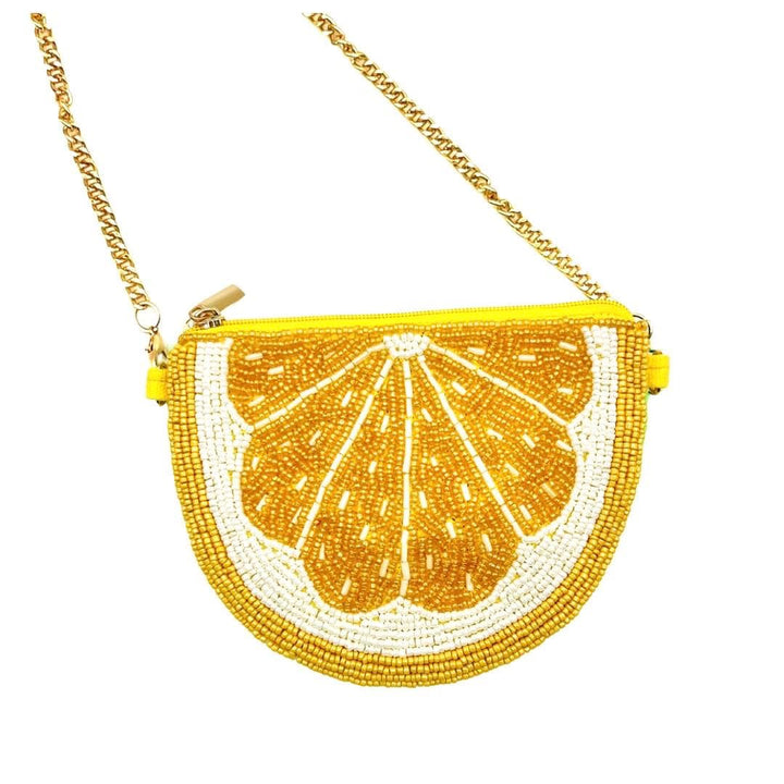 Handbag designed like a lemon slice with beaded details on a white background