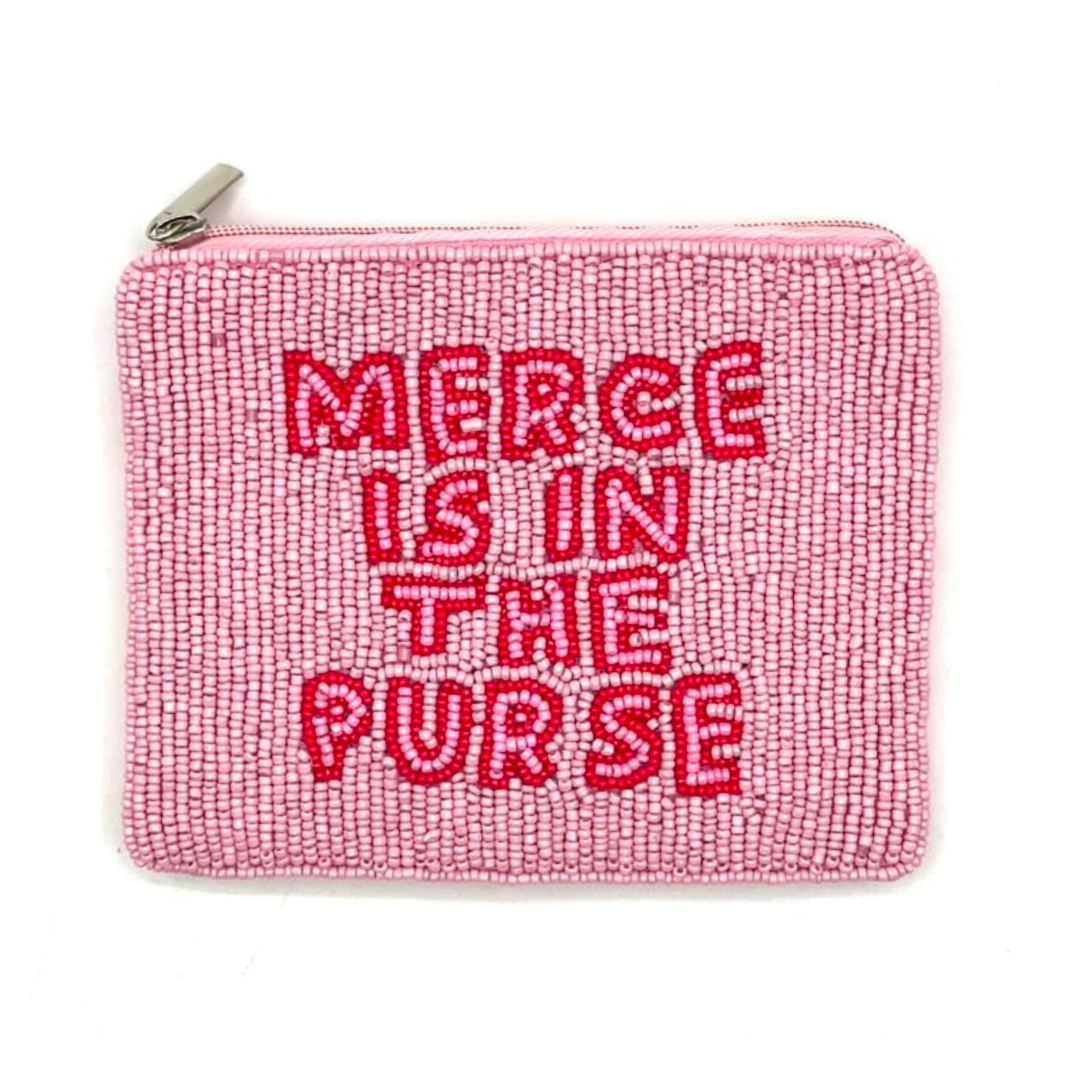Pink purse with red text 'Merce is in the purse' on a white background