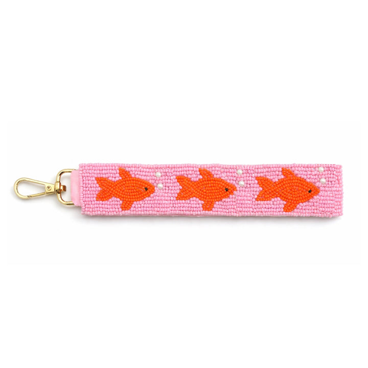 Pink keychain with orange fish design on a white background