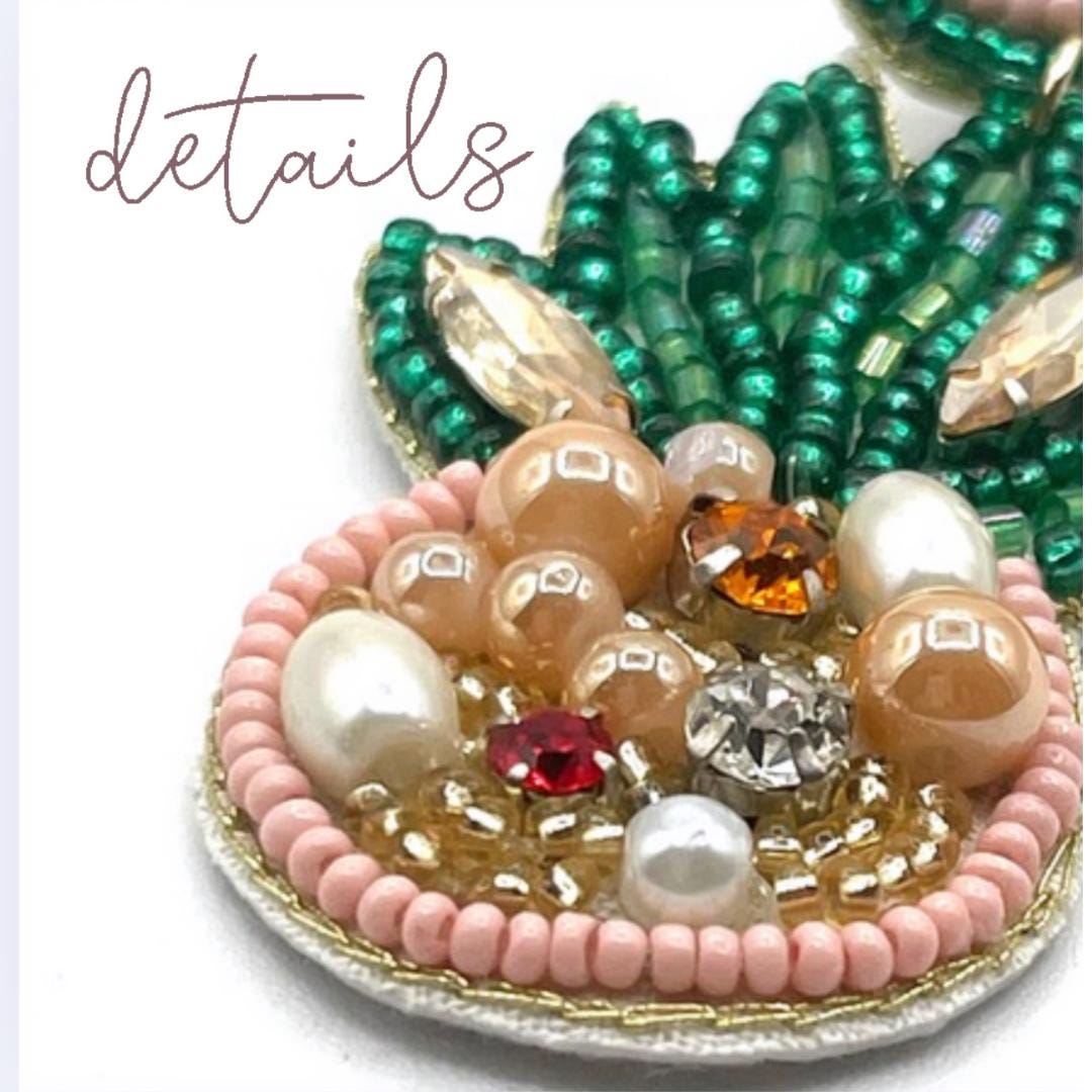 Close-up of a decorative item with beads and pearls on a white background