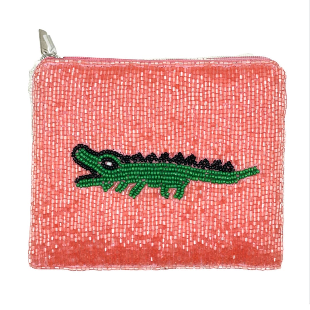 Pink beaded pouch with a green alligator design on a white background