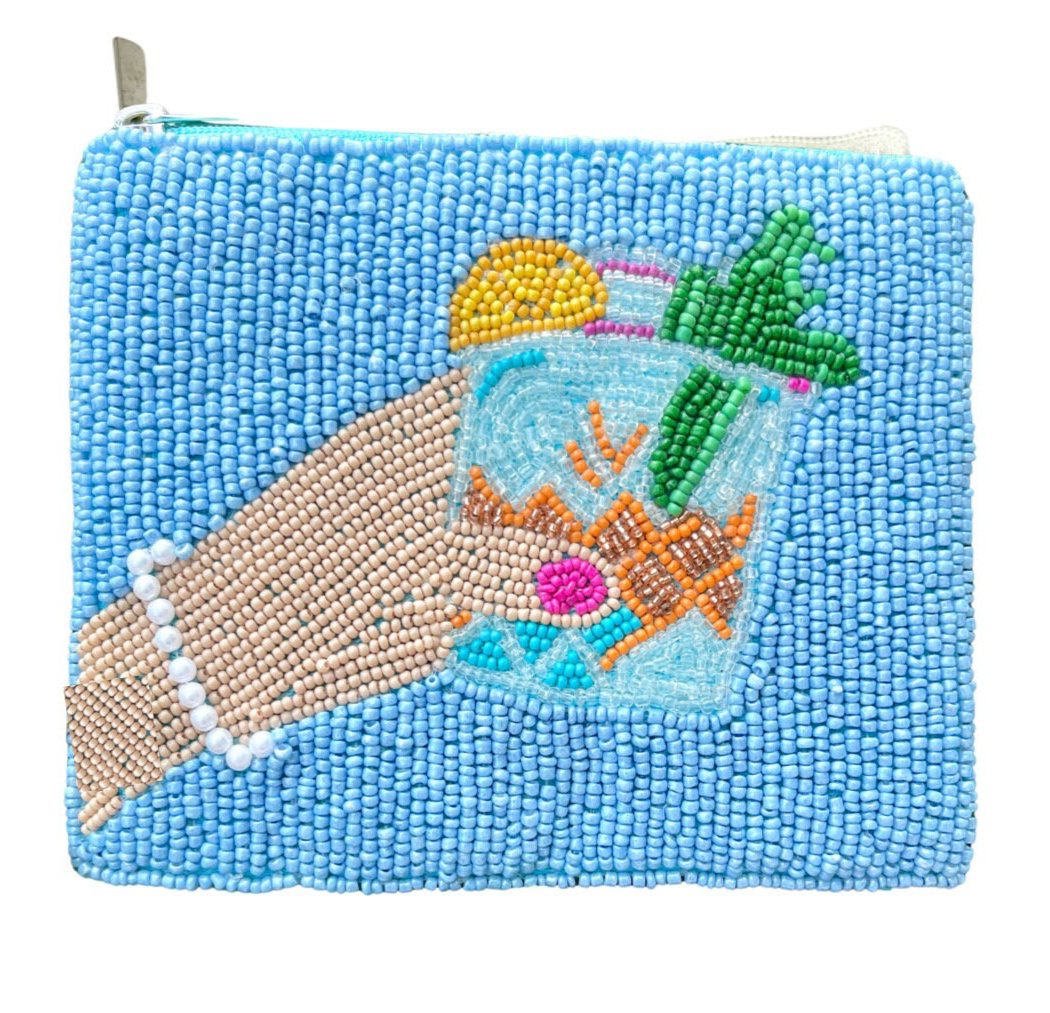 A small beaded coin purse with a blue background featuring a hand-sewn seed beads design of a cocktail glass and fruits on a blue textured background.
