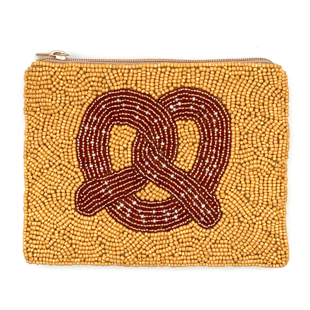 A small, yellow coin purse with a pretzel design, hand-sewn with seed beads, featuring a zipper closure and a canvas backing.