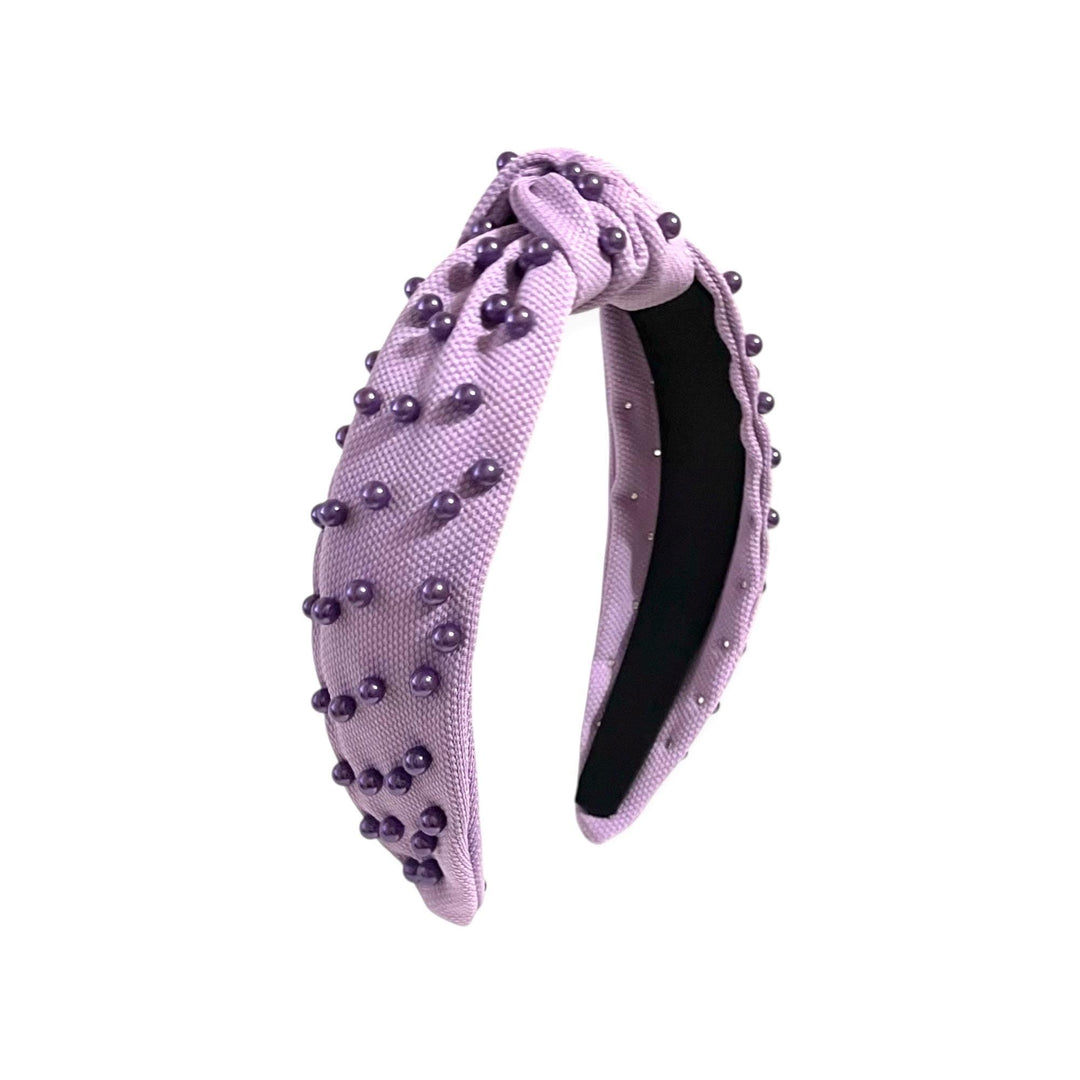 Lavender headband with pearl-like bead embellishments on a white background