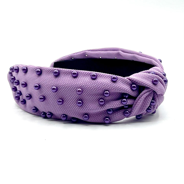 Purple headband with studded details on a white background