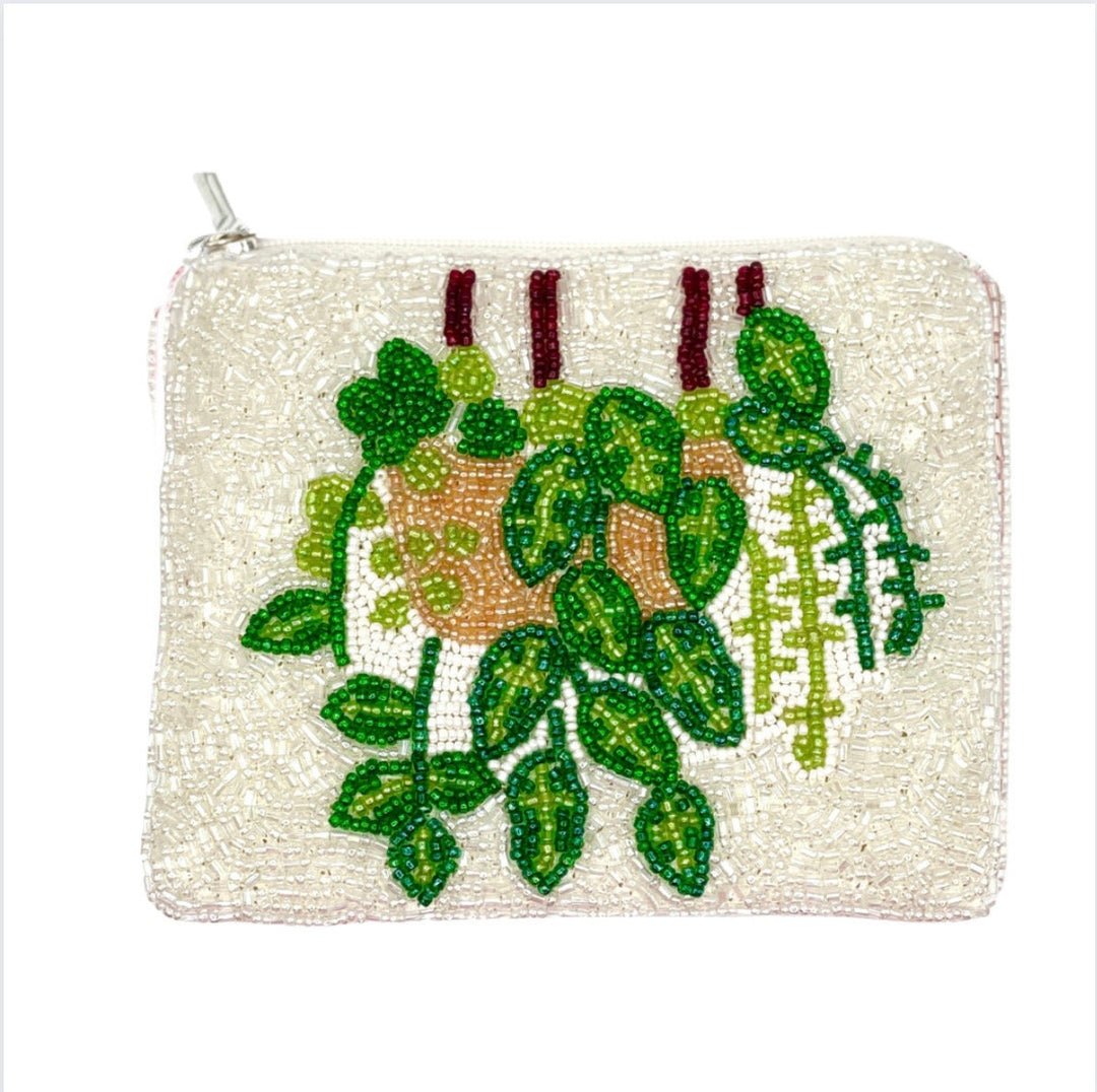 A beaded coin purse with a floral design, featuring green and brown colors and a zipper closure at the top.