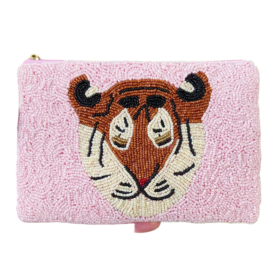 Handheld pink pouch with tiger design against a green leafy background