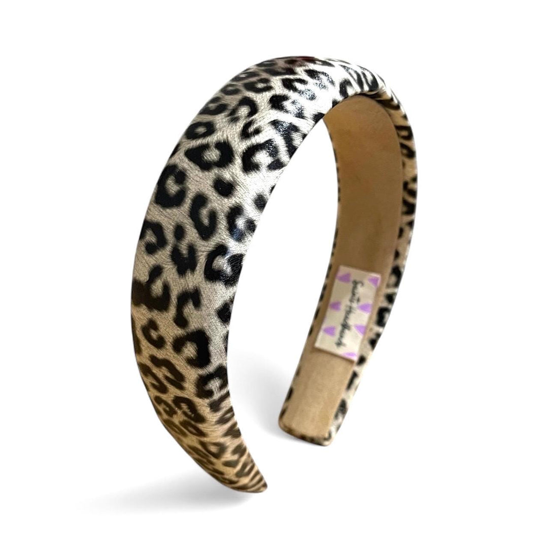 Leopard print headband with a visible brand label on a white background
